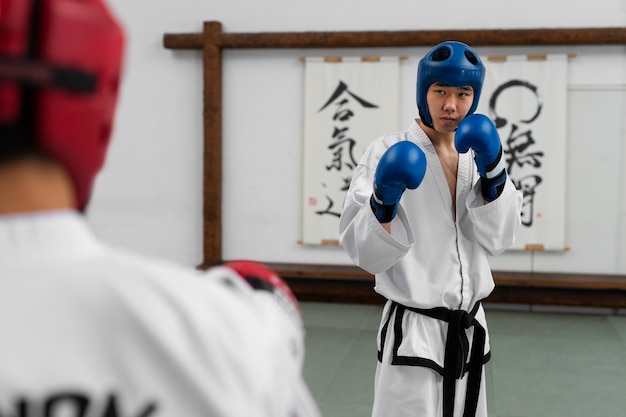 Foto grátis vista frontal de pessoas praticando taekwondo