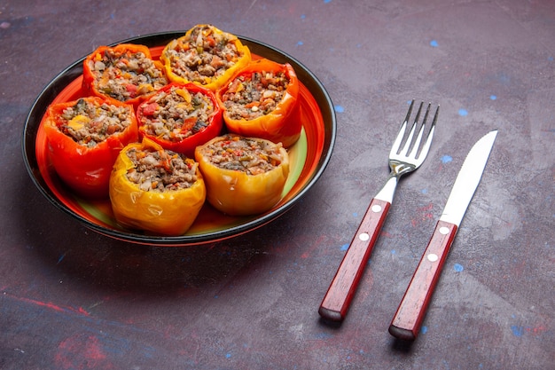 Vista frontal de pimentão cozido com carne moída misturada com temperos em uma refeição de superfície cinza dolma comida vegetais carne bovina