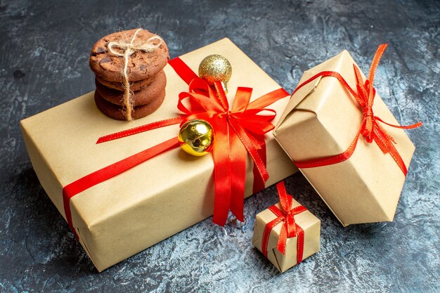 Vista frontal de presentes de natal com biscoitos doces em um feriado claro-escuro foto-presente de natal cor de ano novo