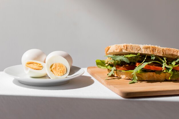 Vista frontal de sanduíche de torrada com tomate e ovos cozidos
