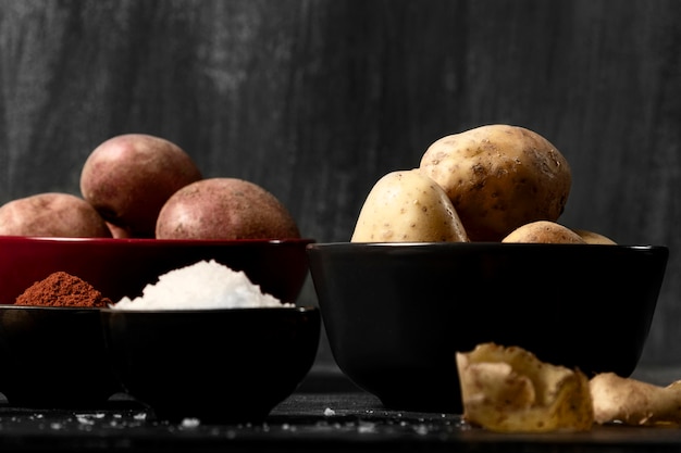 Foto grátis vista frontal de tigelas com batatas e especiarias