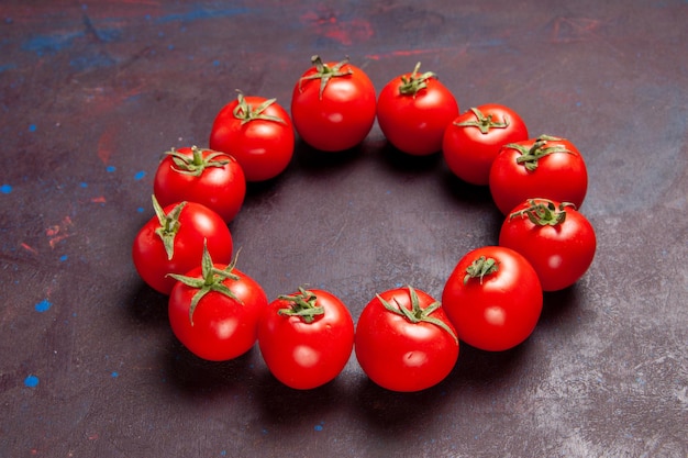 Foto grátis vista frontal de tomates vermelhos frescos circulando no espaço escuro