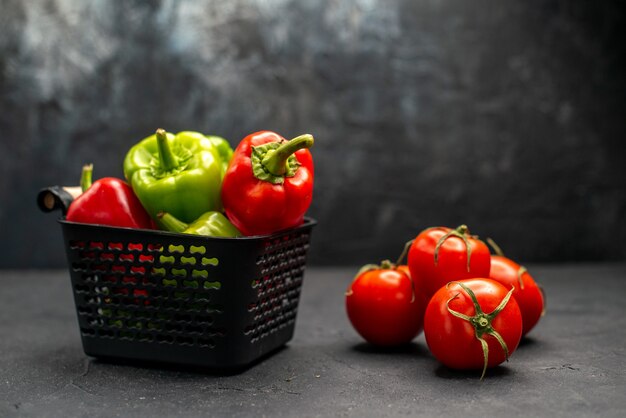 Vista frontal de tomates vermelhos frescos com pimentão no fundo escuro salada de foto colorida de refeição madura