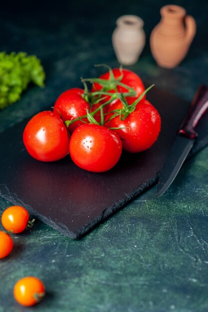 vista frontal de tomates vermelhos frescos em fundo escuro