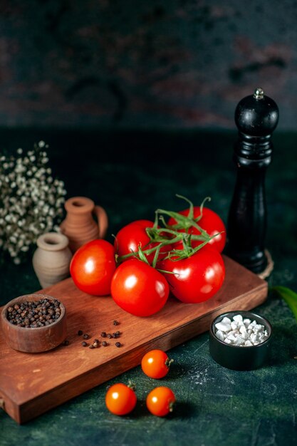 vista frontal de tomates vermelhos frescos em fundo escuro