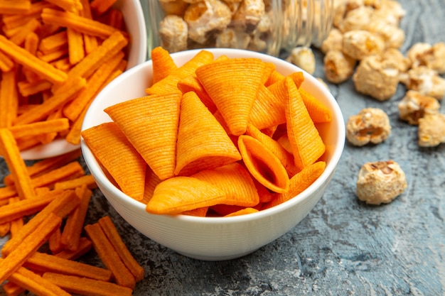 Vista frontal de tostas de queijo com cips e pipoca na mesa leve