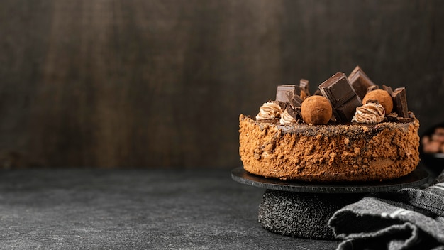 Vista frontal de um delicioso bolo de chocolate em estande com espaço de cópia