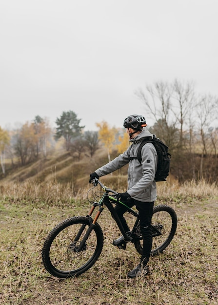 Vista frontal de um homem andando de bicicleta na montanha