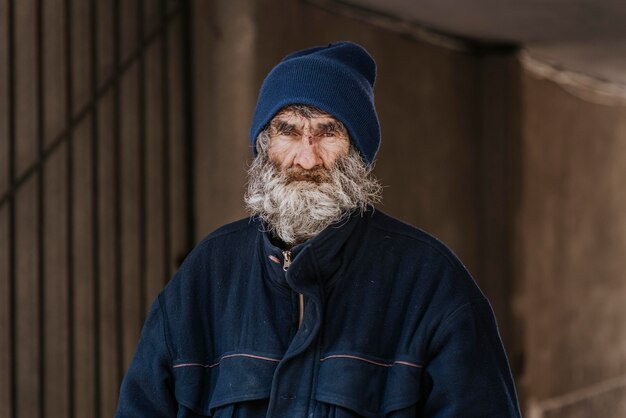 Vista frontal de um homem barbudo sem-teto na rua
