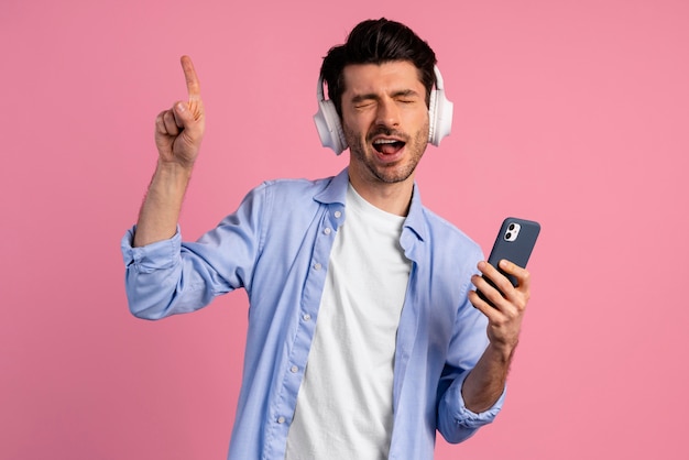 Vista frontal de um homem curtindo música do smartphone em seus fones de ouvido