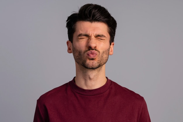 Vista frontal de um homem fazendo beicinho para um beijo