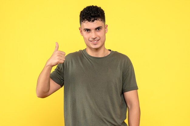 Vista frontal de um homem, o cara sorridente levanta o polegar e olha para a frente