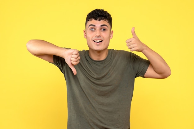 Vista frontal de um homem o homem feliz e sorridente levanta e abaixa os polegares