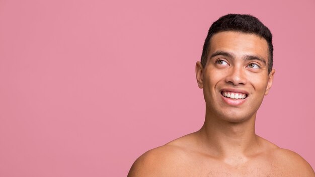 Vista frontal de um homem sorridente posando sem camisa com espaço de cópia