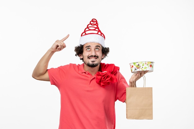 Vista frontal de um jovem entregando comida na parede branca