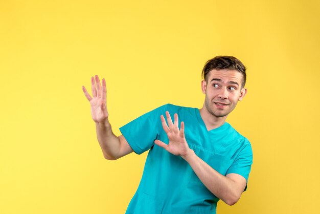 Vista frontal de um médico animado na parede amarelo-claro