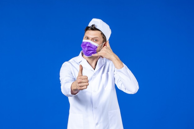 Vista frontal de um médico de terno médico e máscara roxa imitando ligação em azul