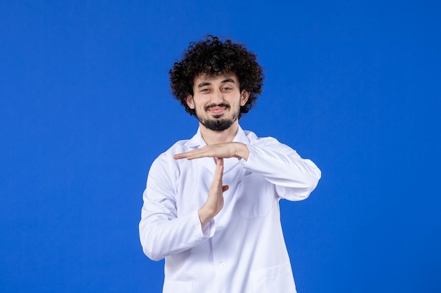 Vista frontal de um médico em terno médico na superfície azul