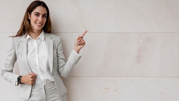 Vista frontal de uma elegante mulher de negócios apontando para a direita