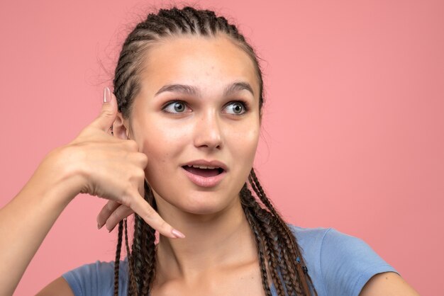 Foto grátis vista frontal de uma jovem imitando telefonema rosa