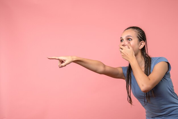 Vista frontal de uma jovem mulher chocantemente olhando rosa