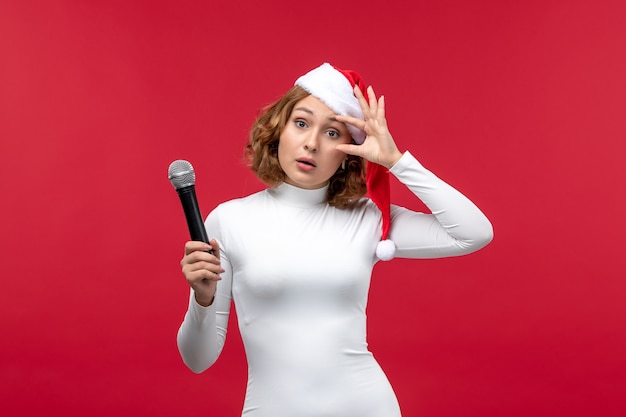 Vista frontal de uma jovem segurando o microfone no vermelho