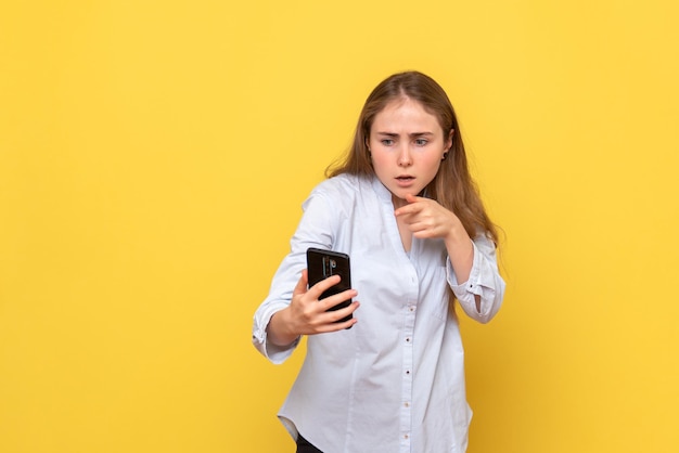 Vista frontal de uma jovem segurando o telefone