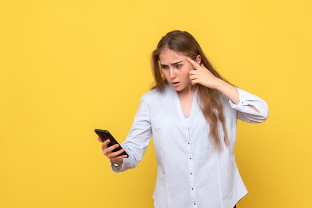 Foto grátis vista frontal de uma jovem segurando o telefone