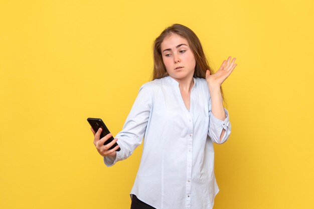 Vista frontal de uma jovem segurando o telefone