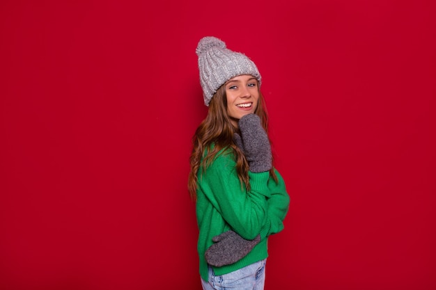 Vista frontal de uma linda jovem com chapéu de malha e suéter verde