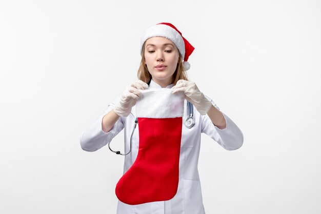 Foto grátis vista frontal de uma médica com uma meia grande de feriado na parede branca