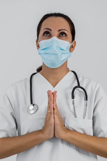 Vista frontal de uma médica orando
