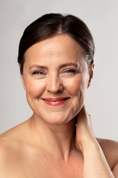 Foto grátis vista frontal de uma mulher madura sorridente posando com maquiagem
