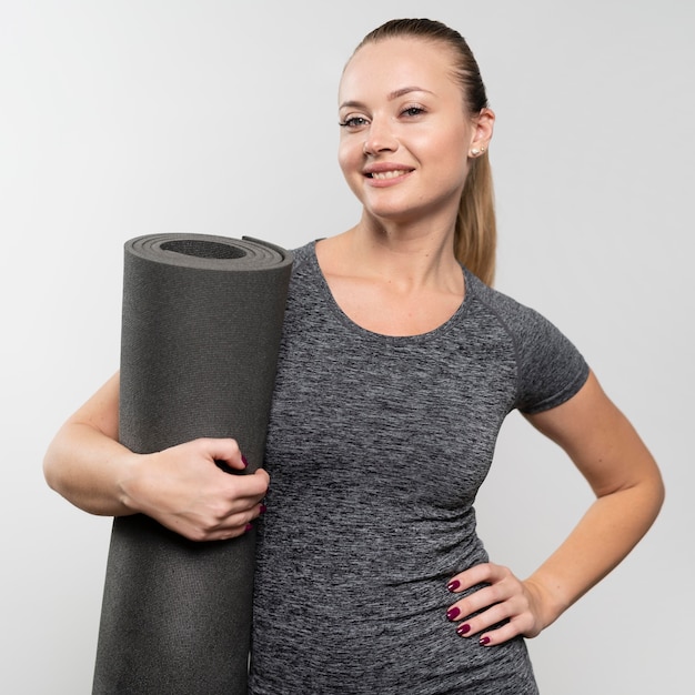 Foto grátis vista frontal de uma mulher sorridente com tapete de fisioterapia