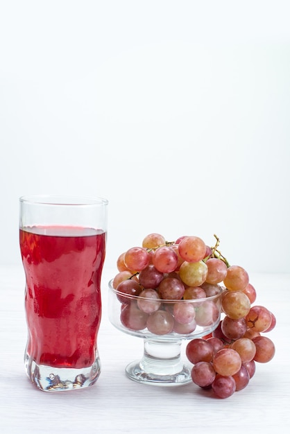 Vista frontal de uvas verdes frescas, frutas ácidas e maduras com suco na superfície branca frutas frescas planta de árvore de vinho suave