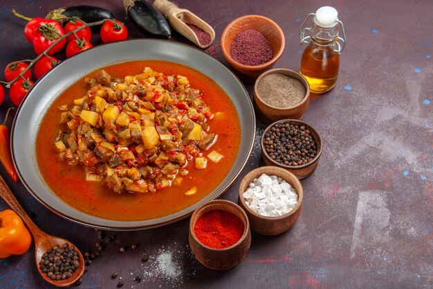 Vista frontal de vegetais cozidos fatiados com molho e temperos em fundo escuro refeição molho comida jantar sopa vegetais