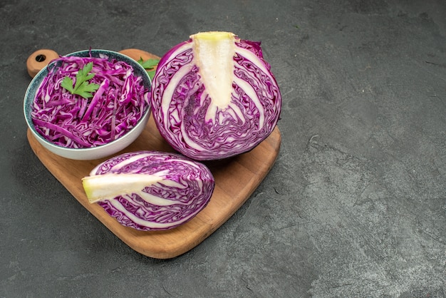 Vista frontal de vegetais fatiados de couve roxa fresca na mesa escura dieta de salada madura de saúde