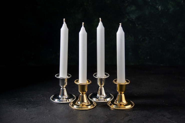 Foto grátis vista frontal de velas brancas em dourado e prateado em preto
