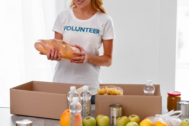 Vista frontal de voluntária preparando doações de alimentos