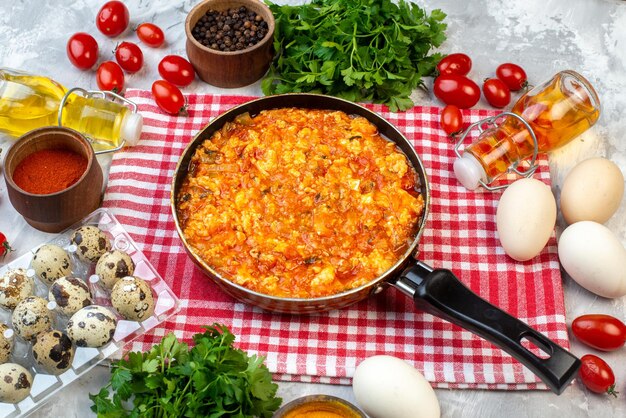 Vista frontal deliciosa omelete com tomate frito em torno de verduras e legumes em fundo branco café da manhã café da manhã pão leite almoço