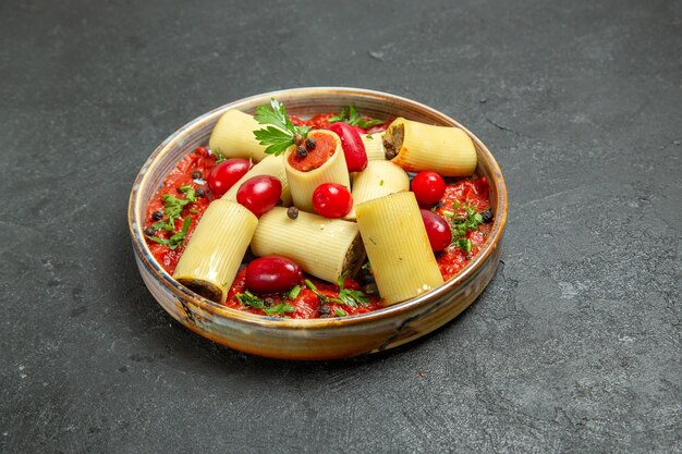 Vista frontal deliciosa refeição de massa italiana cozida com carne e molho de tomate no fundo cinza.