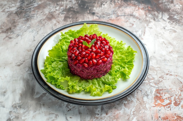 Vista frontal deliciosa salada de romã redonda em forma de salada verde no fundo claro