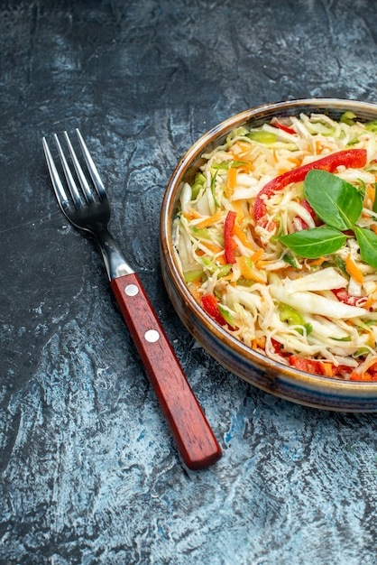 Vista frontal deliciosa salada de vegetais dentro da bandeja na mesa cinza