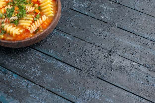 Vista frontal deliciosa sopa de massa italiana em espiral com verduras em fundo escuro prato molho de massa italiana sopa jantar