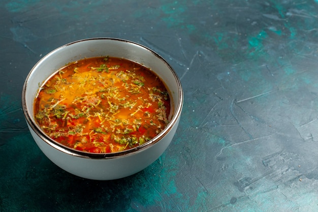 Vista frontal deliciosa sopa de vegetais dentro do prato em superfície verde escura