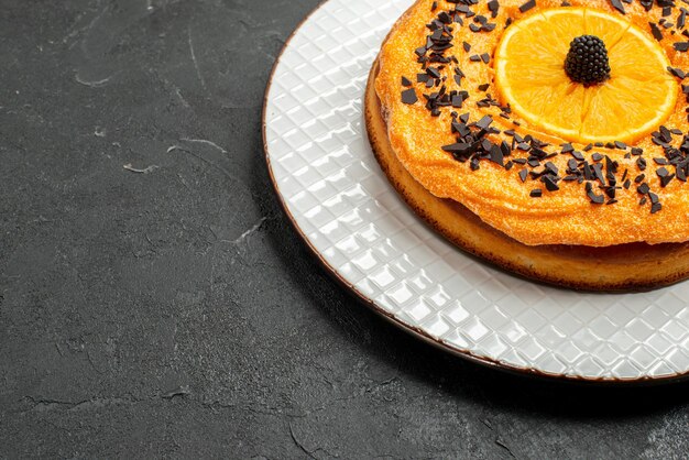 Vista frontal deliciosa torta com gotas de chocolate e fatias de laranja em fundo escuro sobremesa torta de chá bolo biscoito de frutas