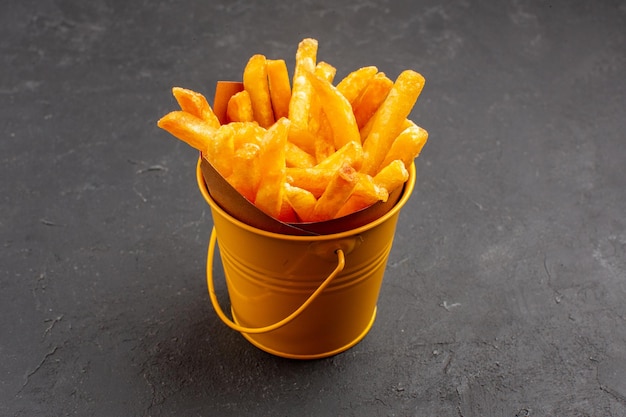 Foto grátis vista frontal deliciosas batatas fritas dentro de uma pequena cesta no espaço escuro