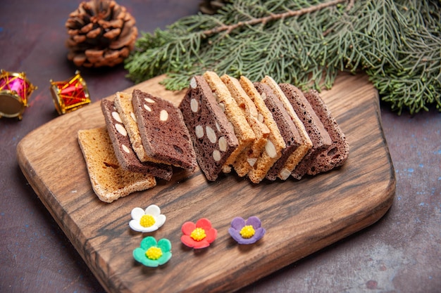 Vista frontal deliciosas fatias de bolo com nozes e cacau no espaço escuro