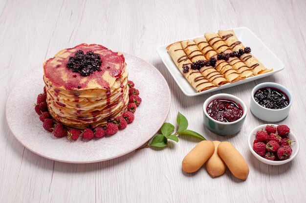 Vista frontal deliciosas panquecas com morangos e geléia na mesa branca torta de frutas biscoito doce bolo baga