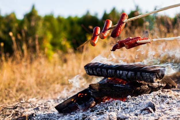 Vista frontal deliciosas salsichas acima do fogo